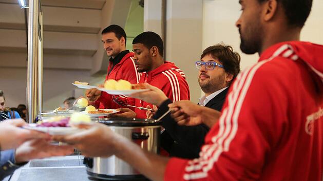 Nach dem Training mit den B&auml;llen, teilten sie am Montag Kl&ouml;&szlig;e und Braten an Bed&uuml;rftige aus: Dalibor Bagaric, Ryan Thompson, Trainer Andrea Trinchieri und Brad Wanamaker (von links) in der Brose Arena. Foto: Barbara Herbst