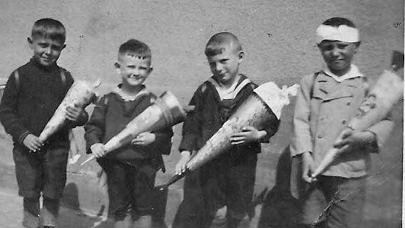 Schulanfang 1935 in Gaustadt, damals im April. Späte 1928er und 1929er Stenglein Andreas, Schmitt Josef, Meisel Hans (+) und Ott Andreas (+). In der Tüte befanden sich wahrscheinlich ein paar Äpfel und ein paar Süßigkeiten schätzt Andreas Stenglein.
