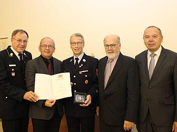 Regierungspr&auml;sident Dr. Eugen Ehmann (2. von links) bei der Aush&auml;ndigung des Steckkreuzes f&uuml;r besondere Verdienste um das Feuerwehrwesen an Klaus W&uuml;scher (Mitte) im Beisein des Stellvertreters des Landrats des Landkreises Bad Kissingen J&uuml;rgen Englert (rechts), des Ersten B&uuml;rgermeisters des Marktes Sulzthal August Weingart (2. von rechts) und des Vorsitzenden des Bezirksfeuerwehrverbandes Unterfranken Benno Metz (links).  Foto: Nicolas Rupp
