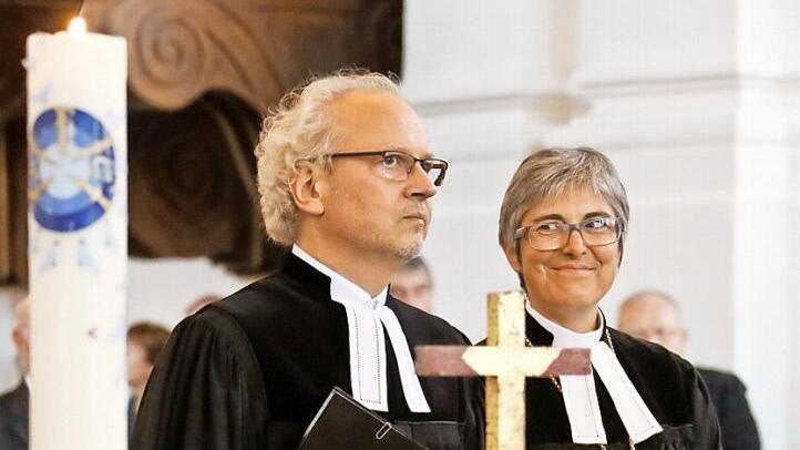 Regionalbischöfin Dorothea Greiner lächelt dem neuen Dekan Hans-Martin Lechner bei der feierlichen Amtseinführung in St. Stephan zu. Foto: Matthias Hoch