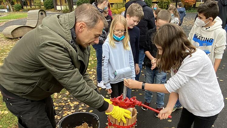 Waschen, pressen, trinken: Der eigenhändig zubereitete frische Apfelsaft schmeckt. Realschul-Direktor Michael Kreil schenkt den Fünftklässlern ein.