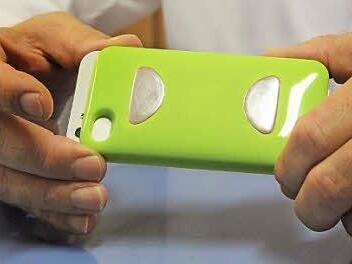 Einfach die Finger auf die zwei Metallscheiben auf der Handyschale legen - mehr ist nicht nötig, um das EKG zu erfassen. Fotos: Simone Bastian