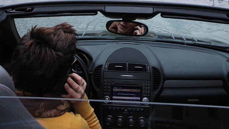Am Steuer telefonieren ist seit 2001 verboten. Unser Bild ist nicht während der Fahrt entstanden. Foto: Roepert