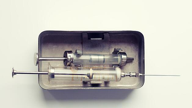 Alte Glasspritzen in einem Metallbehälter Symbolfoto: Cornflowerz, Johannes Menk/Adobe Stock