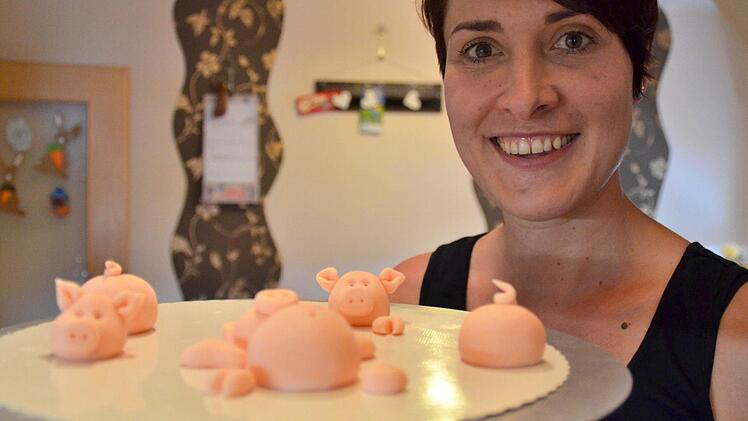 Hier zeigt Verena Schneider ihre selbstgemachten Schweinchen, die später im Schokomatschkübel platziert werden. Fotos: Kathrin Kupka-Hahn