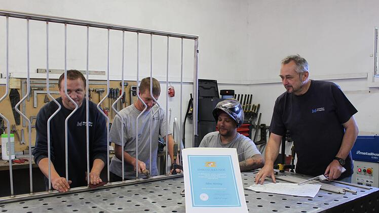 Albin Hertling (r.)  mit Mitarbeitern und ehemaligen Azubis in seiner Werkstatt. Foto: Carmen Schwind