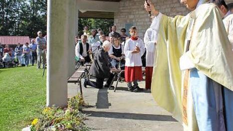 Erzbischof Ludwig Schick weihte gestern die Kräuterbüschel, die die Gläubigen am Freialtar abgelegt hatten. Foto: Birgit Will