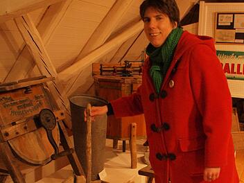 Jana Buhrow am Handwaschgerät. Diese Waschhilfe wurde in einen mit Lauge gefüllten Waschzuber gestellt und die Wäsche zwischen den Holzleisten des feststehenden und des beweglichen Teils bewegt. Der Waschvorgang entspricht dem Vorgang beim Waschen mit der Wäscherumpel.  Foto: Steffi Karl