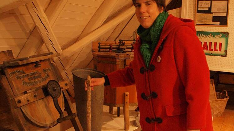 Jana Buhrow am Handwaschgerät. Diese Waschhilfe wurde in einen mit Lauge gefüllten Waschzuber gestellt und die Wäsche zwischen den Holzleisten des feststehenden und des beweglichen Teils bewegt. Der Waschvorgang entspricht dem Vorgang beim Waschen mit der Wäscherumpel.  Foto: Steffi Karl