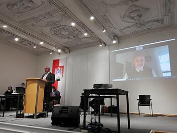 Christian Friemelt informierte via Live-Zuschaltung in der Alten Aula über die Auslagerung der kommunalen Parküberwachung. Für den Münnerstädter Stadtrat war eine solche Hybrid-Veranstaltung eine Premiere. Foto: Heike Beudert