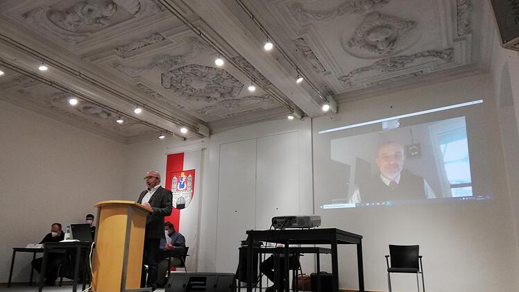 Christian Friemelt informierte via Live-Zuschaltung in der Alten Aula über die Auslagerung der kommunalen Parküberwachung. Für den Münnerstädter Stadtrat war eine solche Hybrid-Veranstaltung eine Premiere. Foto: Heike Beudert