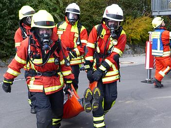 Die Atemschutztrupps bringen  eine geborgene Person mit dem Rettungstuch aus der Gefahrenzone. Foto: Klaus-Peter Wulf