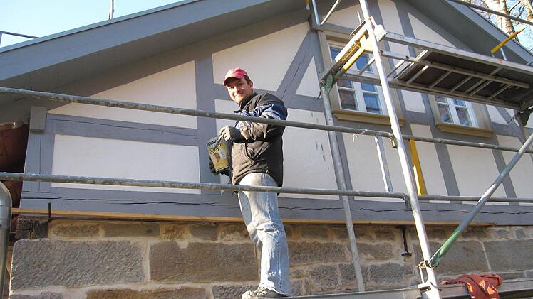 Der Bauherr beim Anstrich der Fachwerkbalken.