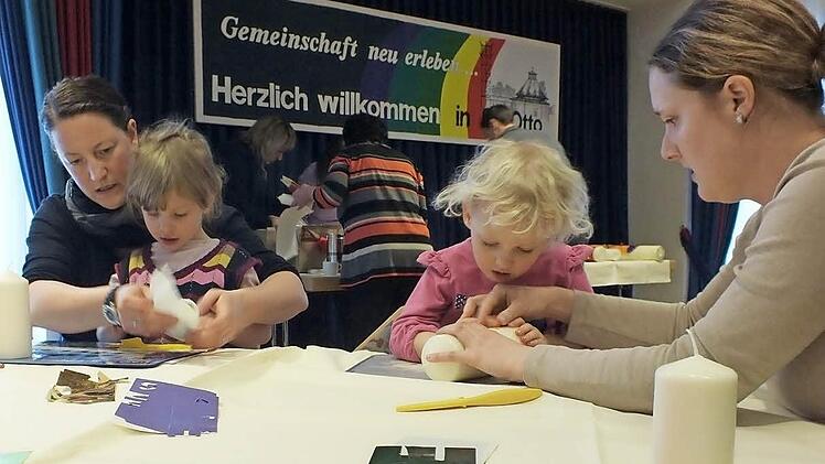Nina und Amelie gestalten ihre Kerzen mit Hilfe ihrer Mütter. Foto: Manfred Welker