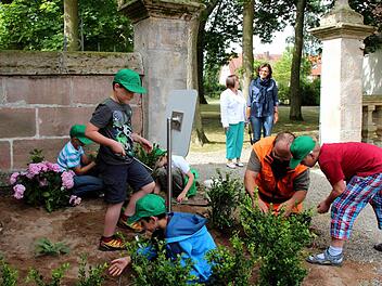 Markus Großkopf (2. v. r.) erklärte den Kindern, wie sie die Pflanzen richtig in den Boden bringen. Im Hintergrund freuten sich Schulleiterin Sieglinde Gröger (l.) und Lehrerin Eva Schlegel über die gelungene Aktion. Fotos: Johanna Blum
