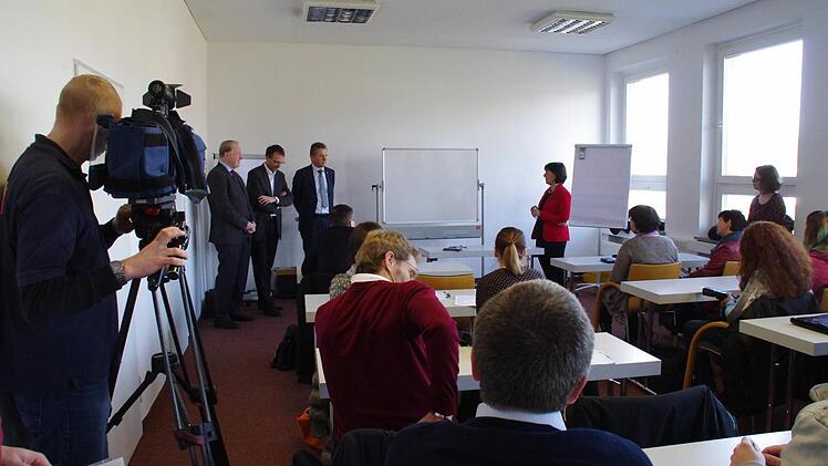 Der neue Studiengang in Kronach weckt gleichermaßen das Interesse von Politik, Betrieben und Medien. Vorgestellt wurden das Projekt und seine Geschichte von (hinten von links) MdB Hans Michelbach, Hochschulpräsident Michael Pötzl sowie IHK-Vizepräsident Hans Rebhan in einem Seminarraum bei Loewe. Foto: Marco Meißner