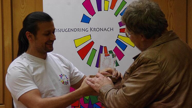 Vorsitzender Andy Fischer (l.) verlieh seinem Vorgänger Martin Schinnerer eine eigens für ihn angefertigte Auszeichnung mit dem in Glas gesetzten Logo des Kreisjugendrings. Foto: Marco Meißner