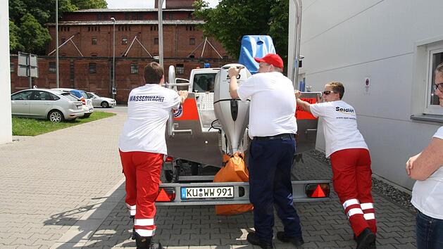 Tim P&ouml;hlmann, Einsatzleiter Thomas Weich und Uli Peschel (von links) montieren den Anh&auml;nger mit dem Boot ans Einsatzfahrzeug: Sie sind bereit f&uuml;r den n&auml;chsten Einsatz in Deggendorf. Foto: Katrin Geyer