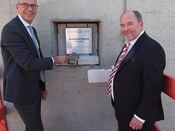 Landrat Christian Meißner (links) und der Regiomed-Hauptgeschäftsführer Joachim Bovelet führten höchstpersönlich die Grundsteinlegung für die Regiomed-Zentralküche aus. Foto: Alfred Tghieret
