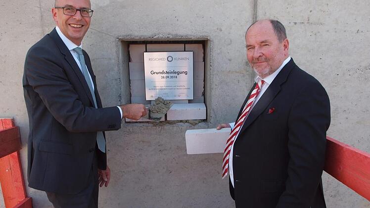 Landrat Christian Meißner (links) und der Regiomed-Hauptgeschäftsführer Joachim Bovelet führten höchstpersönlich die Grundsteinlegung für die Regiomed-Zentralküche aus. Foto: Alfred Tghieret