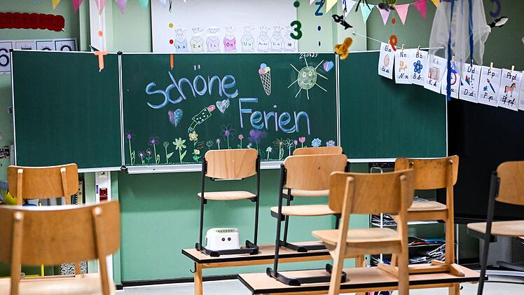 Hochgestellte Stühle und eine bemalte Tafel am letzten Schultag