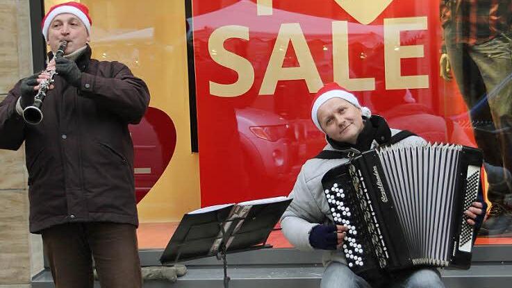 Das Duo aus der Ukraine macht sich nichts aus dem großen Geschäft. Es spielt weihnachtliche Weisen und hofft auf milde Gaben.