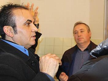 Rasol Herish (links) übersetzt, was Waldemar Mai (Mitte) dem syrischen Flüchtling gerade über die Funktionsweise der Stromsparleuchte im Bad erzählt hat. Foto: Helke Renner