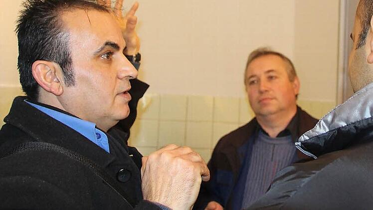Rasol Herish (links) übersetzt, was Waldemar Mai (Mitte) dem syrischen Flüchtling gerade über die Funktionsweise der Stromsparleuchte im Bad erzählt hat. Foto: Helke Renner