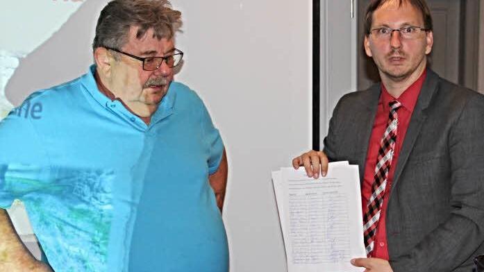 Otto Hanft (links) übergab an Bürgermeister Wolfram Thein (rechts) eine Petition mit mehr als 30 Unterschriften, damit das schnelle Internet für Dippach forciert wird. Foto: Helmut Will