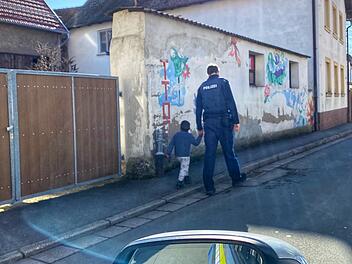 "Schnell Vertrauen gefasst": Ein Vierjähriger, der in Strullendorf von zu Hause weggelaufen war, freundete sich mit einem Beamten der Polizei Bamberg-Land an, wie dieses Foto zeigt. Der Polizist brachte den kleinen Ausreißer schließlich zu seinem Vater.