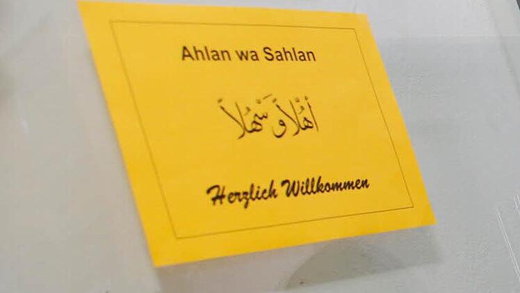 Der Hausmeister hat ein Schild an die Tür des Übergangswohnheims geklebt, das die Syrer in mehrern Sprachen ""Herzlich willkommen" heißt. Foto: Matthias Hoch