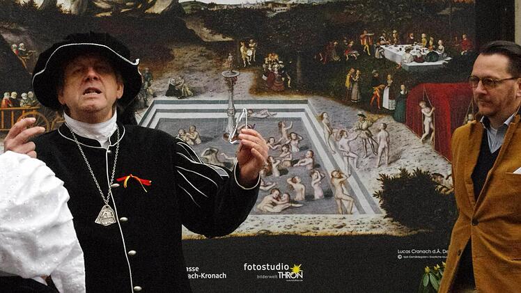 Stadtvogt Hans Götz (links) führte den historisch gewandeten Tross durch die Obere Stadt. Mit dem Museologen Alexander Süß zeigte er das Jungbrunnen-Gemälde in den Fenstern. Foto: Marco Meißner