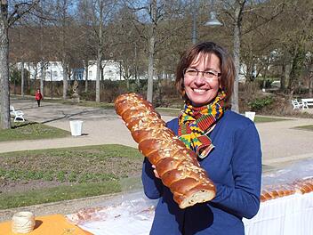 Rund 1400 Euro sind bei der Osterbrot-Aktion in Bad Bocklet zusammengekommen. Karin Gabel vom Organisationsteam präsentiert einen Teil des 25 Meter langen Gebäcks. Foto: Björn Hein