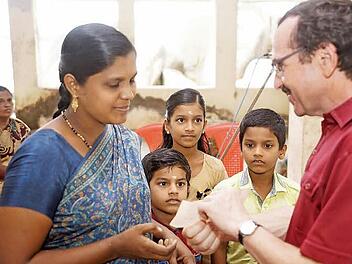 Eine Fischerwitwe mit ihren drei Kindern bekam von Pfarrer Walter Ries 700 Euro als Soforthilfe von ZMS überreicht.  Foto: Gerd Albert
