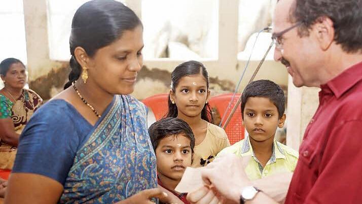 Eine Fischerwitwe mit ihren drei Kindern bekam von Pfarrer Walter Ries 700 Euro als Soforthilfe von ZMS überreicht.  Foto: Gerd Albert