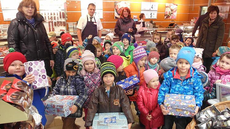 Die Kinder des Kindergartens St. Josef in Wildflecken übergaben die Geschenkpäckchen an Filialleiter Viktor Krause (Metzgerei Robert Müller) im Rewe-Markt Wildflecken. Von links die Erzieherinnen Anneliese Porada, Brigitte Winkler und Henrike Reder, in der Mitte Viktor Krause. Foto: bra