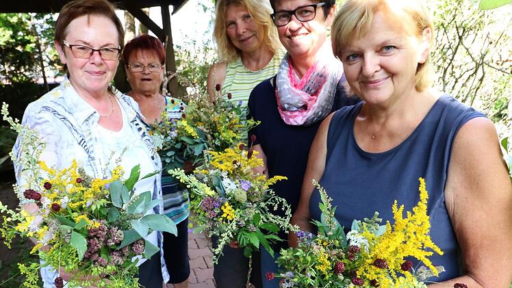 "Wir binden, was wir gefunden haben", erklärt Ulrike Nöth (zweite von rechts), die mit den Frauen der Pfarrei Don Bosco  Wurzbüschel bindet.