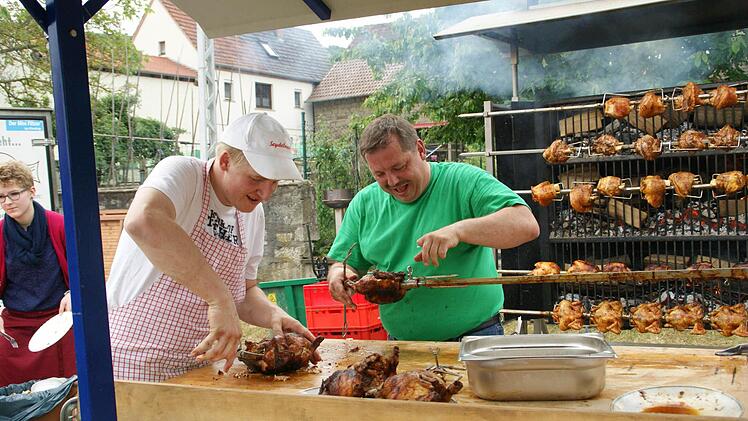 Alle Hände voll zu tun hatten Thomas Pflaum (rechts) und Christian Schmitt, denn die Hähnchen und Haxen vom Holzgrill fanden reißenden Absatz. Foto: Sabine Weinbeer