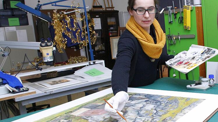 Kerstin Wittenburg bessert eine schadhafte Stelle an einem Gemälde von Georg Tappert aus.  Foto: Josef Hofbauer