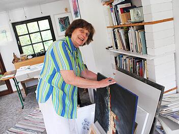Die Zeichen- und Aquarell-Dozentin Heide Kunze-Lysek blättert in ihren Werken.  Fotos: Carolin Herrmann