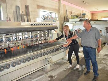 Robert Karg mit Tochter Larissa am Kantenschleifautomaten in der Werkstatt, in der Natursteine millimetergenau zugeschnitten werden. Foto: eh