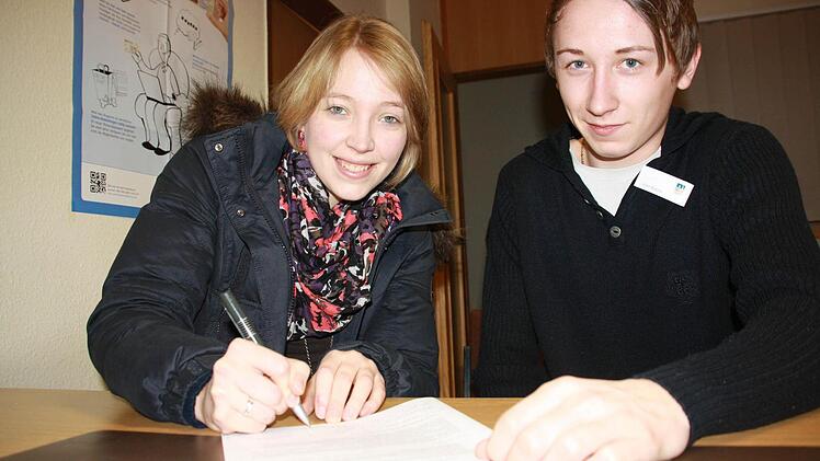 Mona Lückenhaus will dazu beitragen, dass die Studiengebühren abgeschafft werden. Julien Wagner, Azubi bei der Stadt, erklärt ihr, wo ihr Autogramm hin soll.