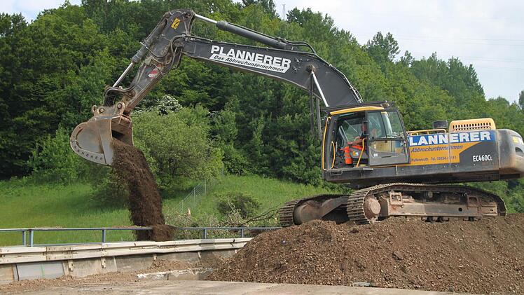 Ein Bagger schaufelt noch schnell etwas Erde beiseite.