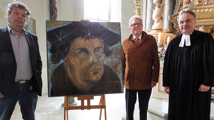 Übergabe des Luther-Porträts an die Evangelische Kirchengemeinde. Von links Künstler Stephan Klenner-Otto, Dekan i.R. Jürgen Zinck und Pfarrer Peter Brünnhäußer.  Foto: Werner Reißaus
