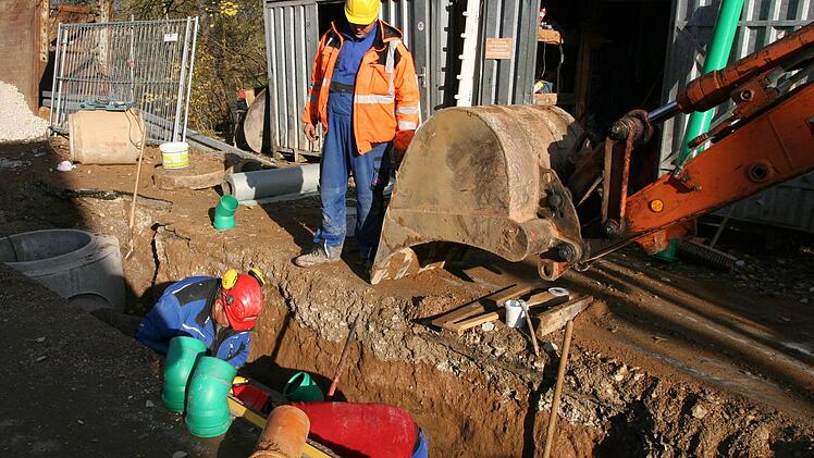 Spatenstich unter dem Schaufelbagger: Bürgermeister Klaus Homann und Angehörige der Fraktionen des Marktgemeinderats packen zusammen mit der Baufirma Köhler aus Lisberg sowie dem Bauingenieur Hans-Jürgen Sauer ein 320 000 Euro teures Abwasser-Projekt an. Foto: wb