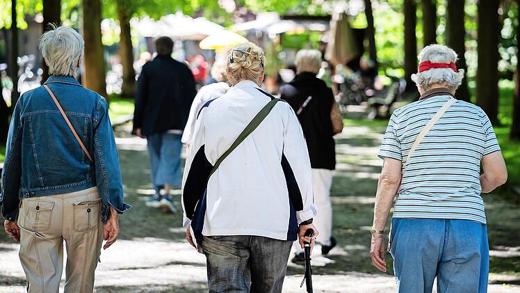 Frauen gehen bei einem Spaziergang gegen Einsamkeit f&uuml;r &auml;ltere Menschen durch einen Park.