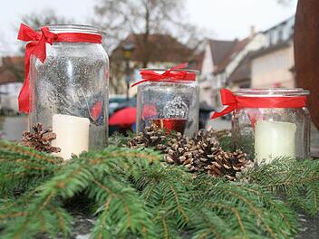 Immer ein Hingucker: Schöne Kerzengläser mit Zweigen, Schleifen und Zapfen verziert.   Foto: Anja Vorndran