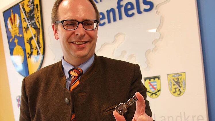 Landrat Christian Meißner hält einen USB-Stick in der Hand, auf dem Informationen über dem Landkreis gespeichert sind. Er gehört zu einem Faltblatt, mit dem das Landratsamt die Region Lichtenfels jungen Famlien vorstellt. Foto: Tobias Kindermann