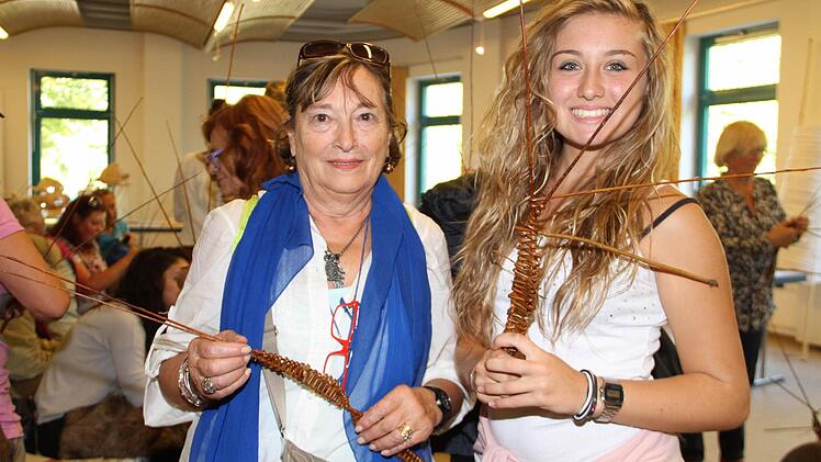 Maria Speranzini (links) und Eleonora Di Rocchi sind mit ihren ersten Flechtversuchen zufrieden.  Foto: Gerda Völk