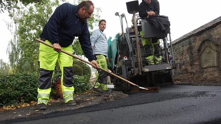 Arbeiter tragen die Deckschicht auf. Foto: Arkadius Guzy